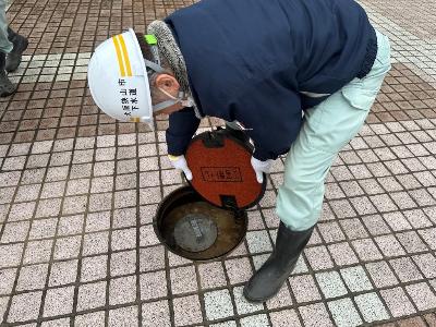 災害用マンホールトイレの設置のために蓋を開ける様子