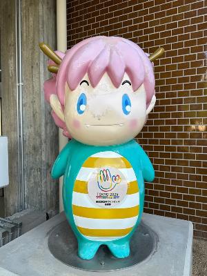 東京2025デフリンピックのエンブレムを着用した市役所本庁舎前のさやりん像