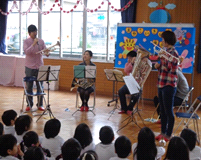 園でこども達が演奏を聴いている写真