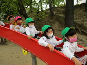 こども達が滑り台ですべっている写真